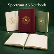 Cream, burgundy and green Spectrum A6 notebooks with a gold Art Creators logo, and one open with lined pages